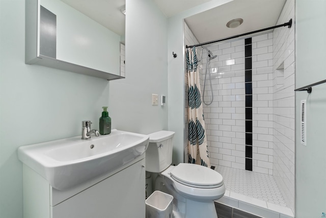 full bathroom with toilet, vanity, and a tile shower