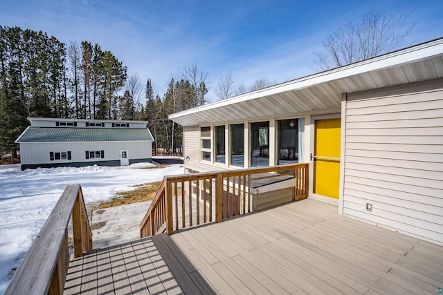 snow covered deck featuring an outbuilding