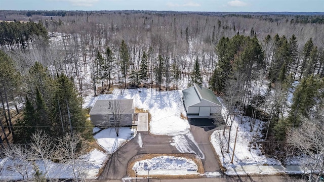 snowy aerial view with a wooded view