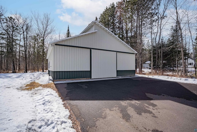 snow covered garage with a detached garage