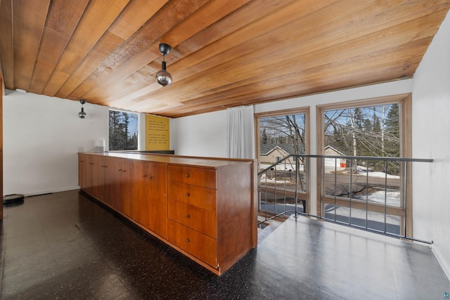 bar featuring baseboards, wooden ceiling, and dark floors