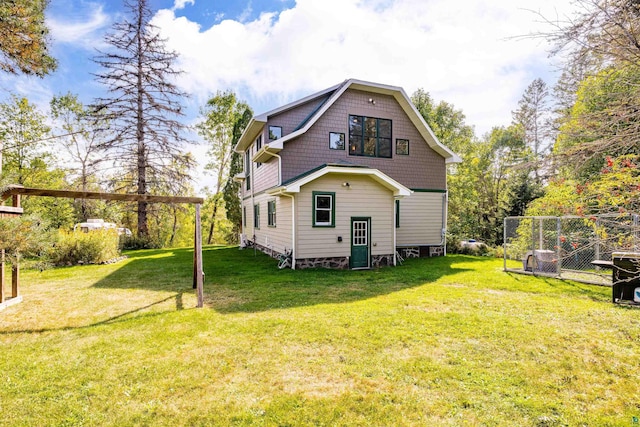 rear view of property featuring a yard and fence