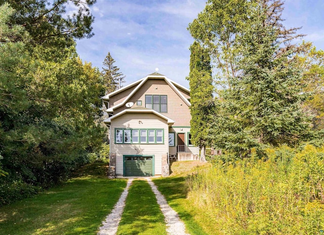 back of house with a lawn, a garage, and driveway