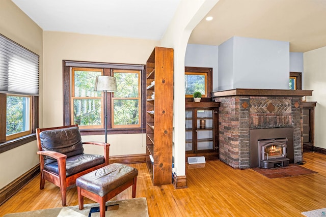 living area with arched walkways, visible vents, baseboards, and hardwood / wood-style floors