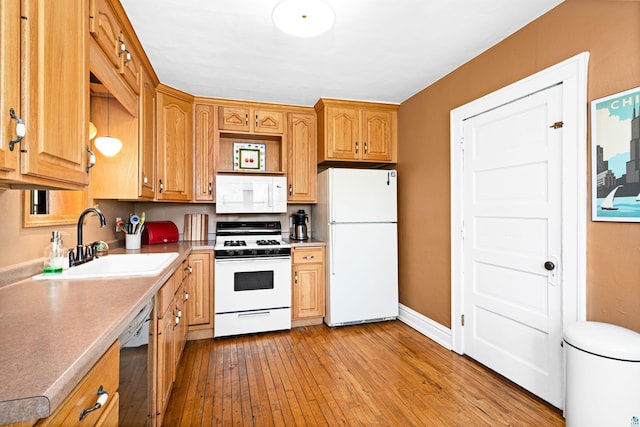 kitchen with light wood-style flooring, a sink, white appliances, light countertops, and baseboards