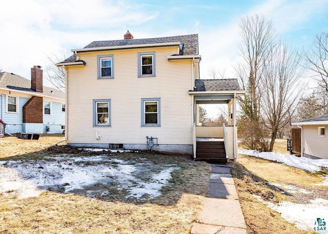 rear view of house with a chimney and a shingled roof