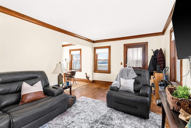 living area with crown molding, baseboards, and wood finished floors