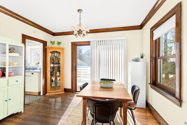 dining area with dark wood finished floors, crown molding, baseboards, and a chandelier