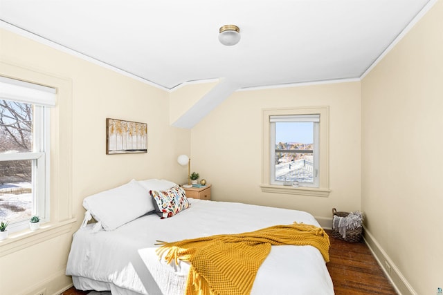 bedroom featuring baseboards, wood finished floors, and crown molding