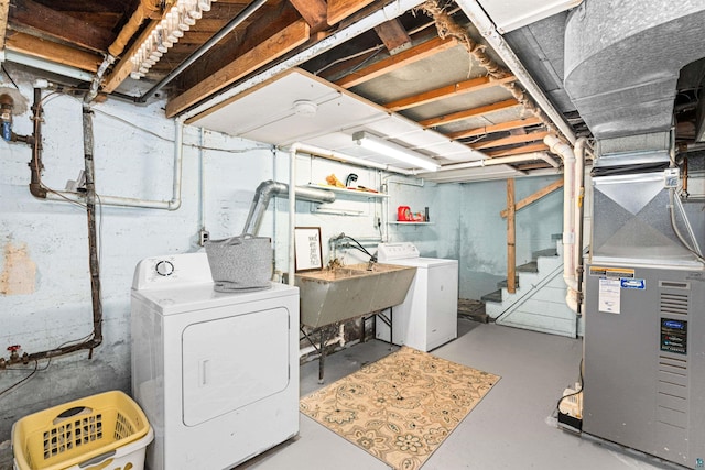 unfinished basement with a sink, stairway, heating unit, and separate washer and dryer