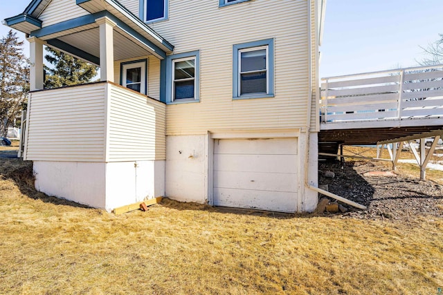 view of side of property featuring a lawn and an attached garage