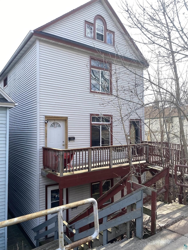 back of property with a wooden deck and stairway