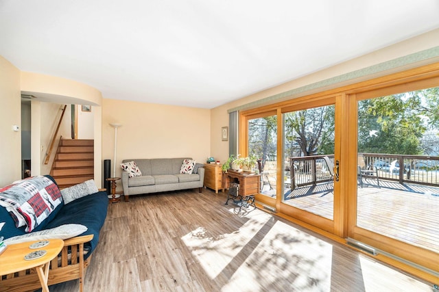 living room featuring stairway, wood finished floors, and visible vents