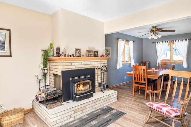 living room with baseboards, wood finished floors, and a ceiling fan