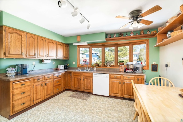 kitchen with a wealth of natural light, dishwasher, light countertops, and a sink