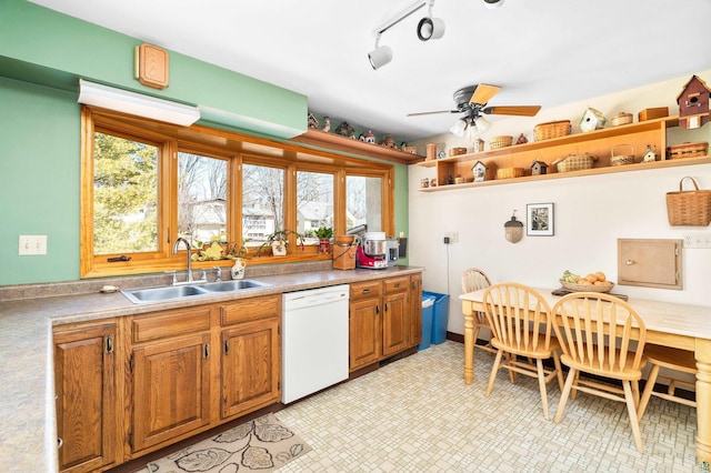 kitchen with brown cabinets, a sink, open shelves, white dishwasher, and ceiling fan