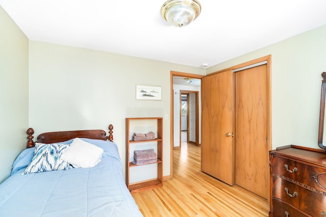 bedroom featuring a closet, baseboards, and light wood-style floors