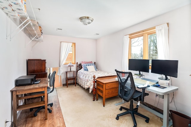 carpeted bedroom featuring visible vents