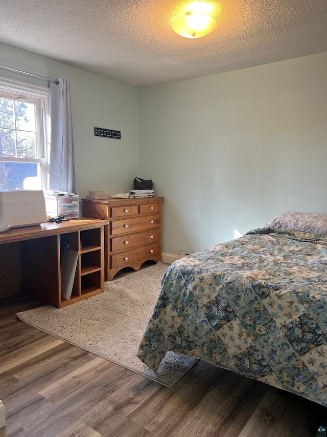 bedroom with wood finished floors and a textured ceiling