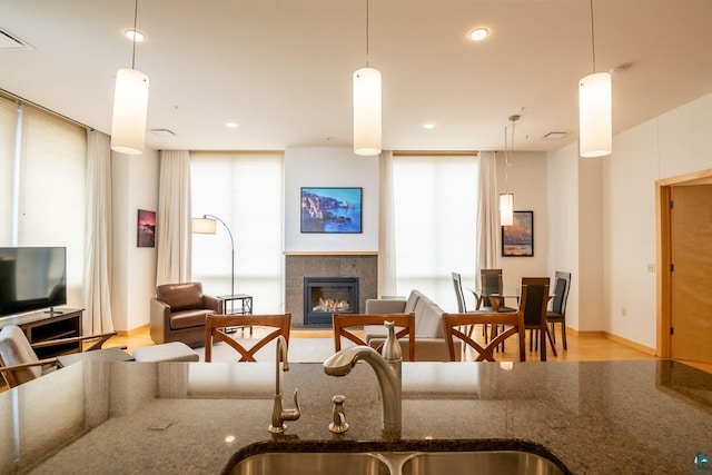 interior space featuring a glass covered fireplace, light wood-type flooring, and baseboards