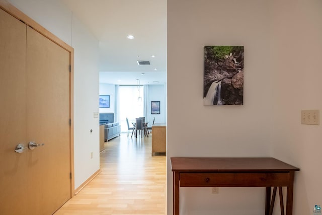 hall with light wood finished floors, visible vents, and recessed lighting