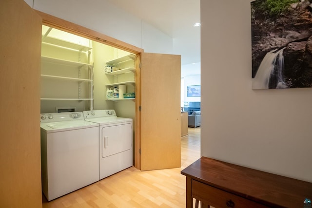 laundry room with washer and clothes dryer, laundry area, and light wood-type flooring