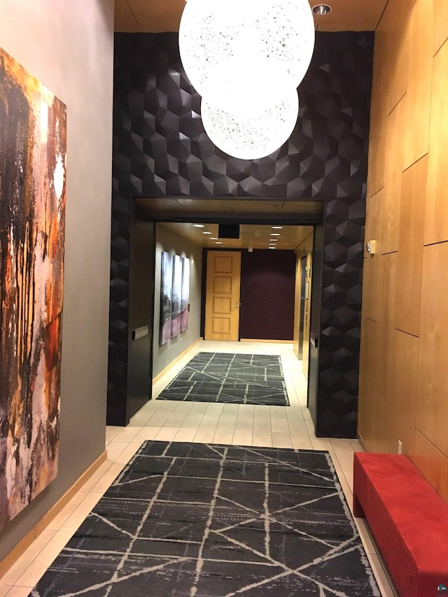 hall with a chandelier, tile patterned floors, and a towering ceiling