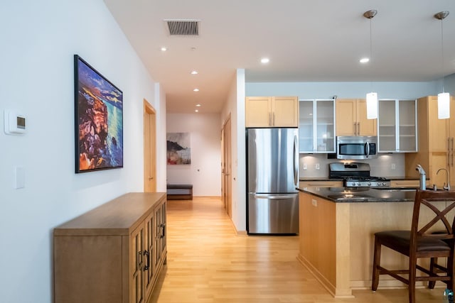 kitchen featuring visible vents, glass insert cabinets, recessed lighting, appliances with stainless steel finishes, and light wood-style floors