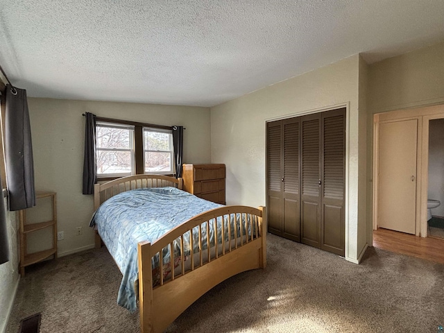 carpeted bedroom with a closet, baseboards, a textured ceiling, and visible vents