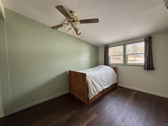 unfurnished bedroom with lofted ceiling, dark wood-style floors, baseboards, and ceiling fan