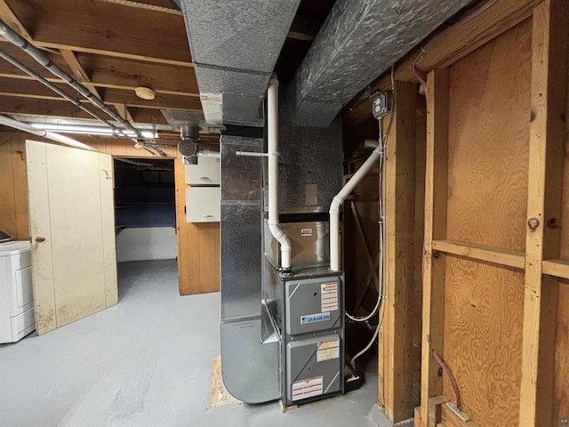 utility room with heating unit and washer / dryer