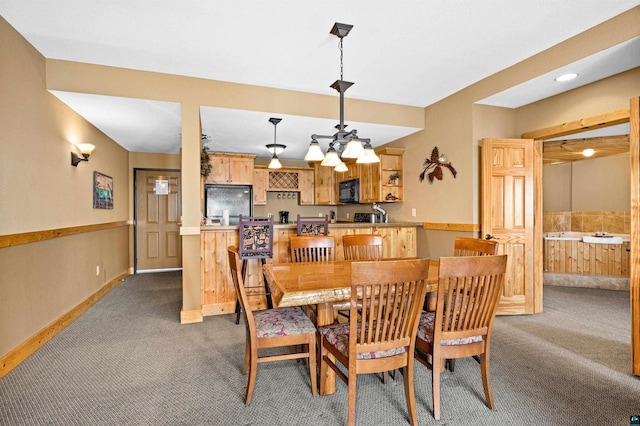 carpeted dining room featuring baseboards and wainscoting