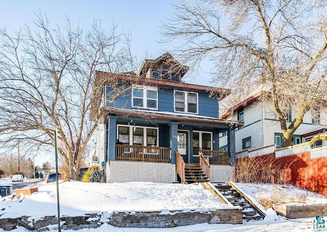 traditional style home featuring stairway, covered porch, and fence