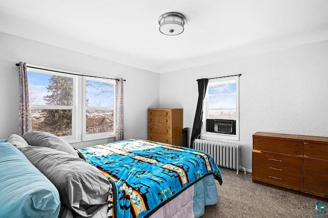 bedroom with cooling unit, radiator, and carpet floors