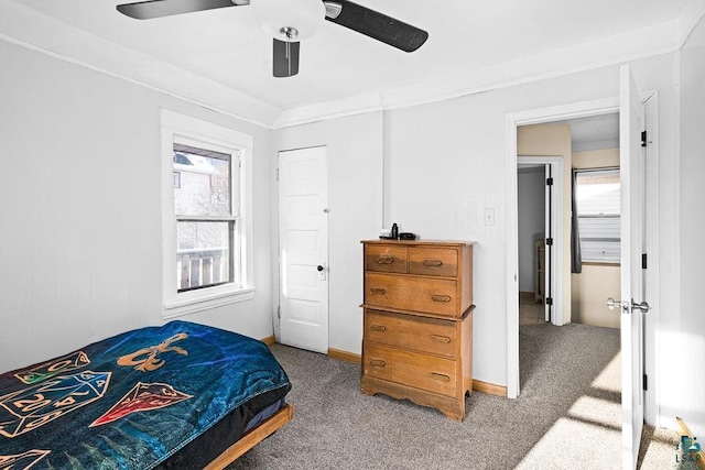 carpeted bedroom featuring baseboards, ornamental molding, and a ceiling fan