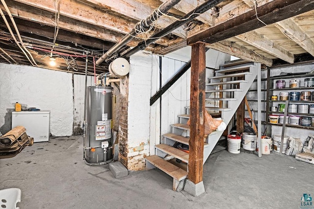 unfinished basement with fridge, stairway, and water heater