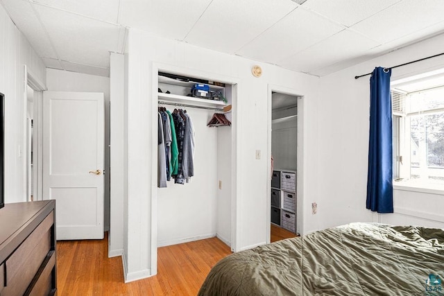 bedroom featuring a closet, baseboards, and light wood-style floors