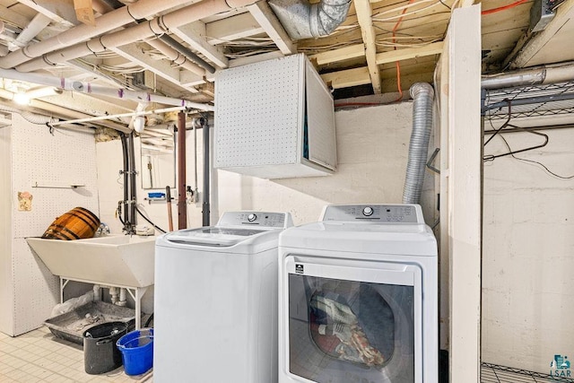 laundry room featuring laundry area, washing machine and dryer, and a sink