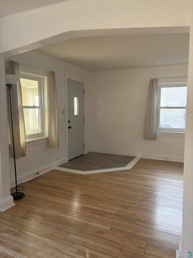 foyer with light wood-style flooring and baseboards