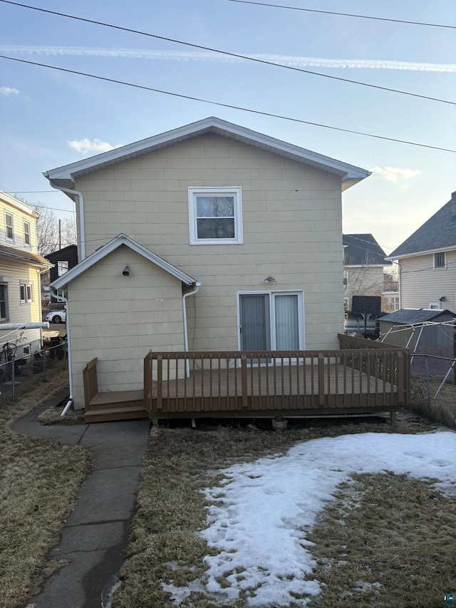 rear view of property featuring fence and a wooden deck