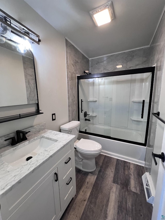 full bath with visible vents, toilet, wood finished floors, enclosed tub / shower combo, and vanity