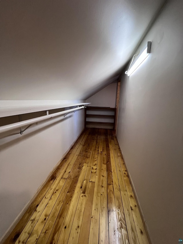 spacious closet featuring light wood-type flooring and lofted ceiling