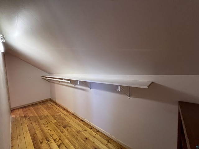 walk in closet with lofted ceiling and light wood-style floors