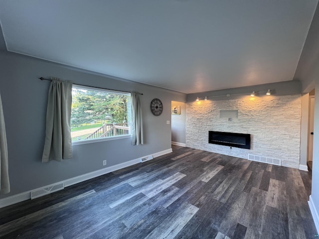 unfurnished living room featuring a fireplace, wood finished floors, and visible vents