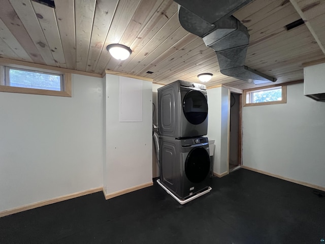 washroom featuring laundry area, stacked washer / dryer, baseboards, and wooden ceiling