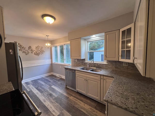 kitchen with dark wood-style flooring, stainless steel appliances, decorative backsplash, a sink, and glass insert cabinets