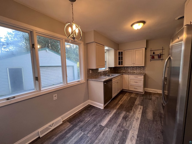 kitchen with tasteful backsplash, visible vents, dishwashing machine, freestanding refrigerator, and a sink