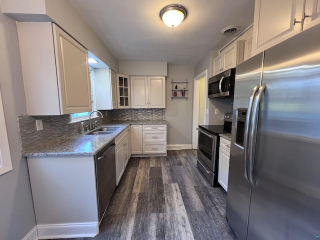 kitchen featuring visible vents, glass insert cabinets, appliances with stainless steel finishes, white cabinetry, and a sink