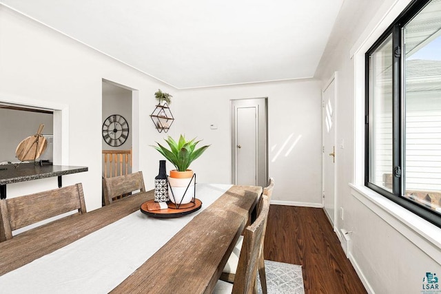 dining area with a wealth of natural light, dark wood finished floors, and baseboards