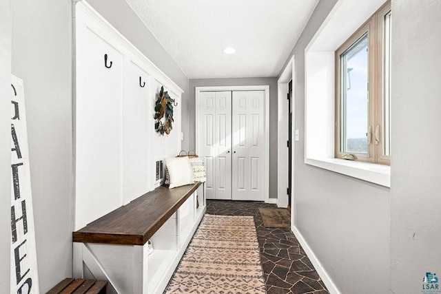 mudroom with stone finish flooring and baseboards